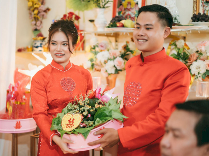 nghi-thuc-le-gia-tien-cong-giao-4-1-dang-trau-cau-hoa-qua-va-niem-huong-kinh-nho-to-tien-13 Cô dâu và chú rể cùng dâng trầu cau và thắp hương trước bàn thờ gia tiên nhà trai